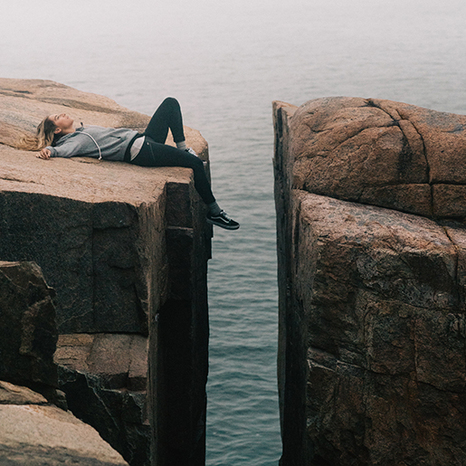 kvinna-ligger-pa-klippor