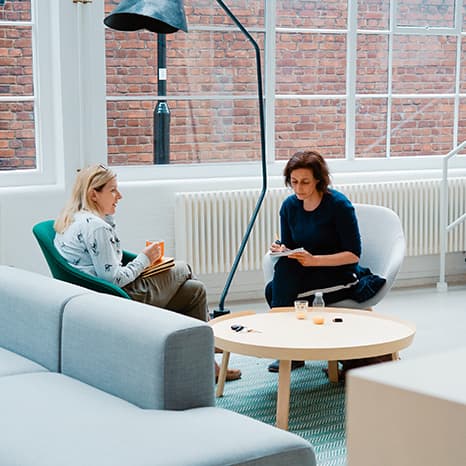 två-kvinnor-som-sitter-i-fåtöljer